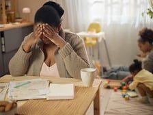 Mom feeling overwhelmed while daughters play in the background