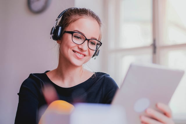 Young girl with headphones on our tablet