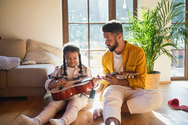 Father showing daughter guitar
