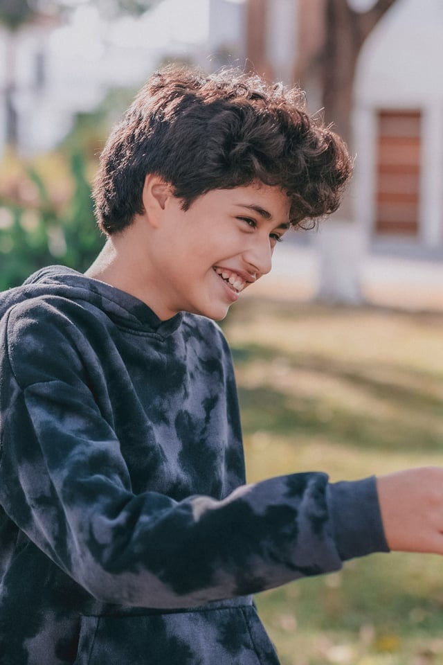 Young boy laughing outside