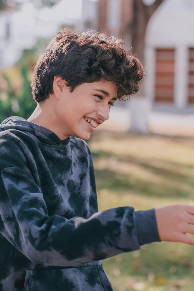 Young boy laughing outside