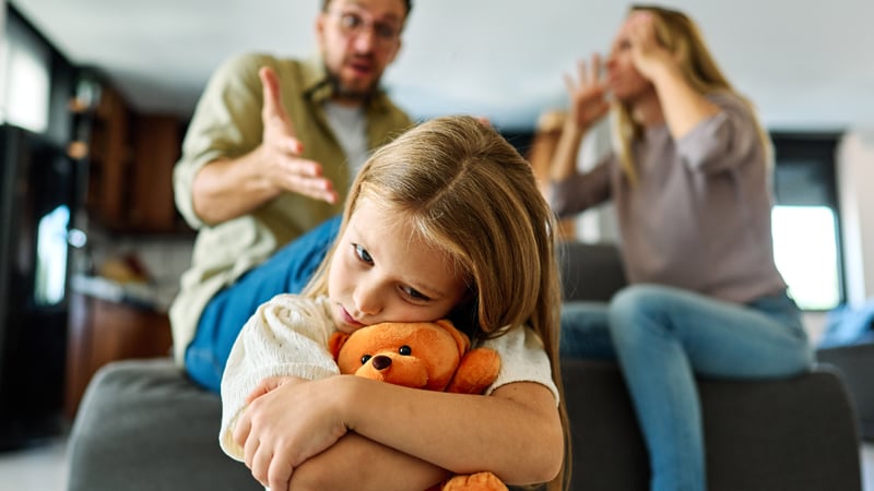 An unhappy girl experiencing unhealthy family dynamics as her parents argue