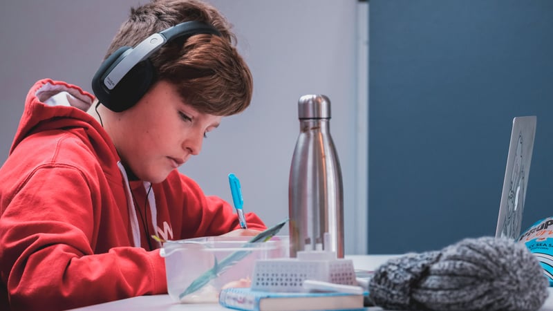 Kid with headphones that has adhd doing homework