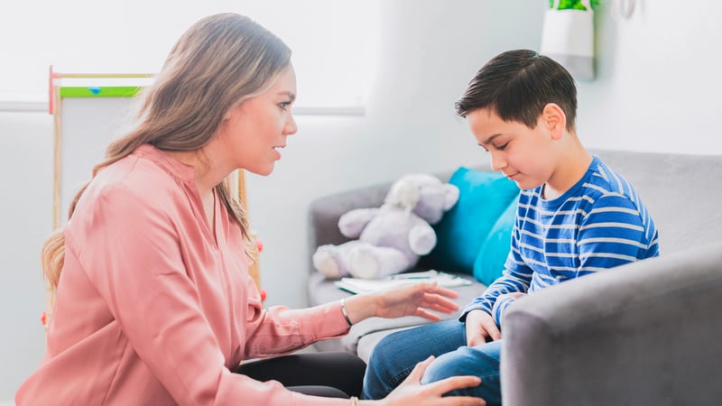 Female therapist talking to a kid in a therapy session
