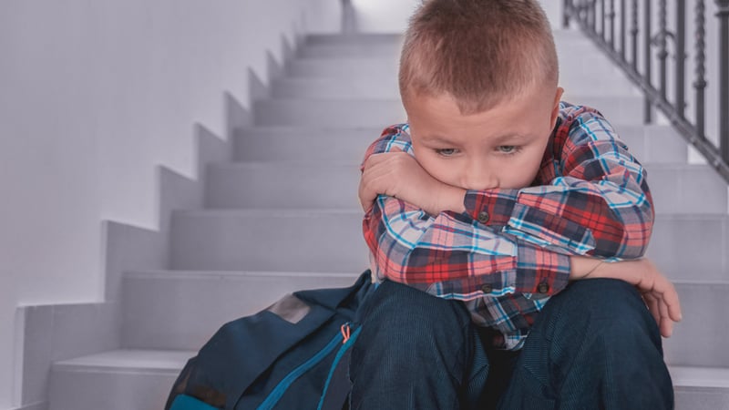 Kid sitting on the stairs sad from being bullied