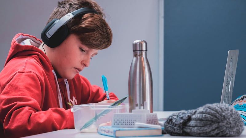 Kid with headphones that has adhd doing homework