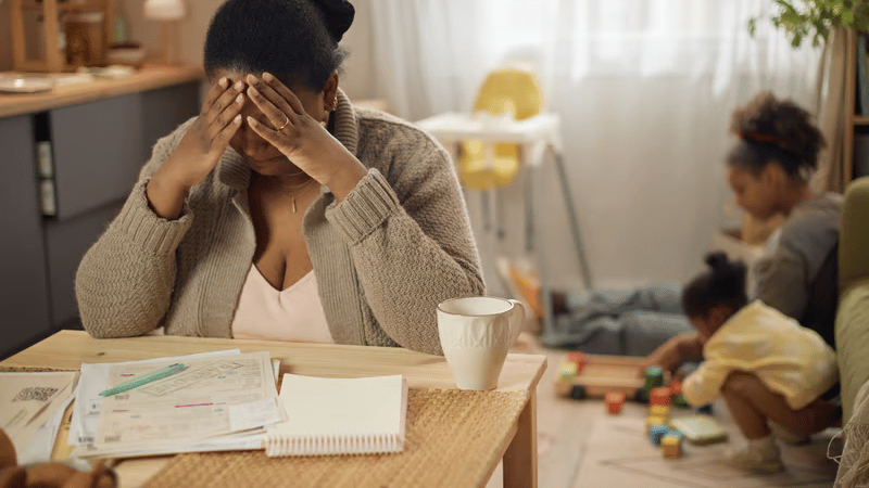 Mom feeling overwhelmed while daughters play in the background