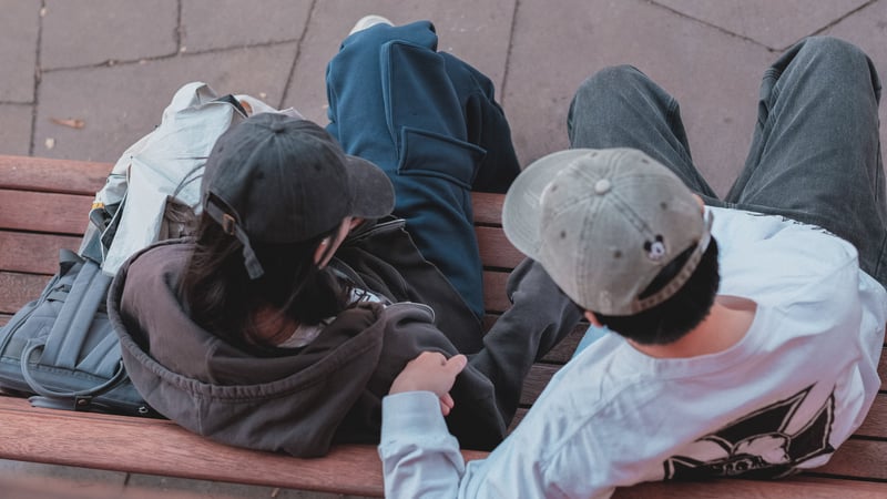 Teen couple talking on a bench