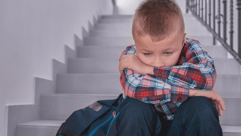 Kid sitting on the stairs sad from being bullied