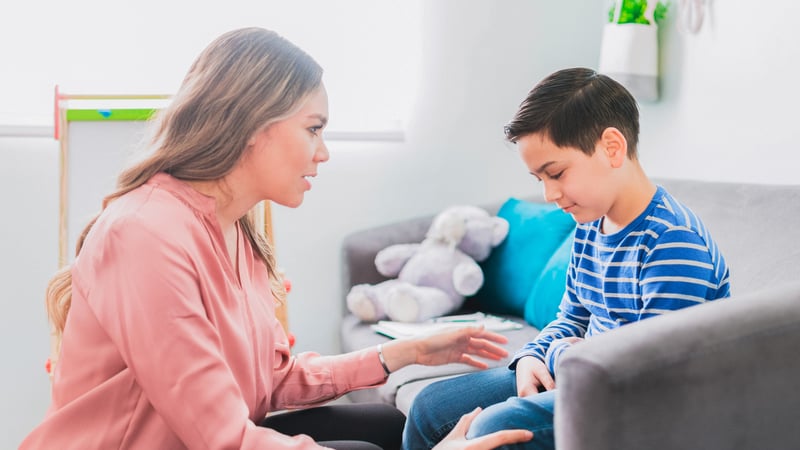 Female therapist talking to a kid in a therapy session