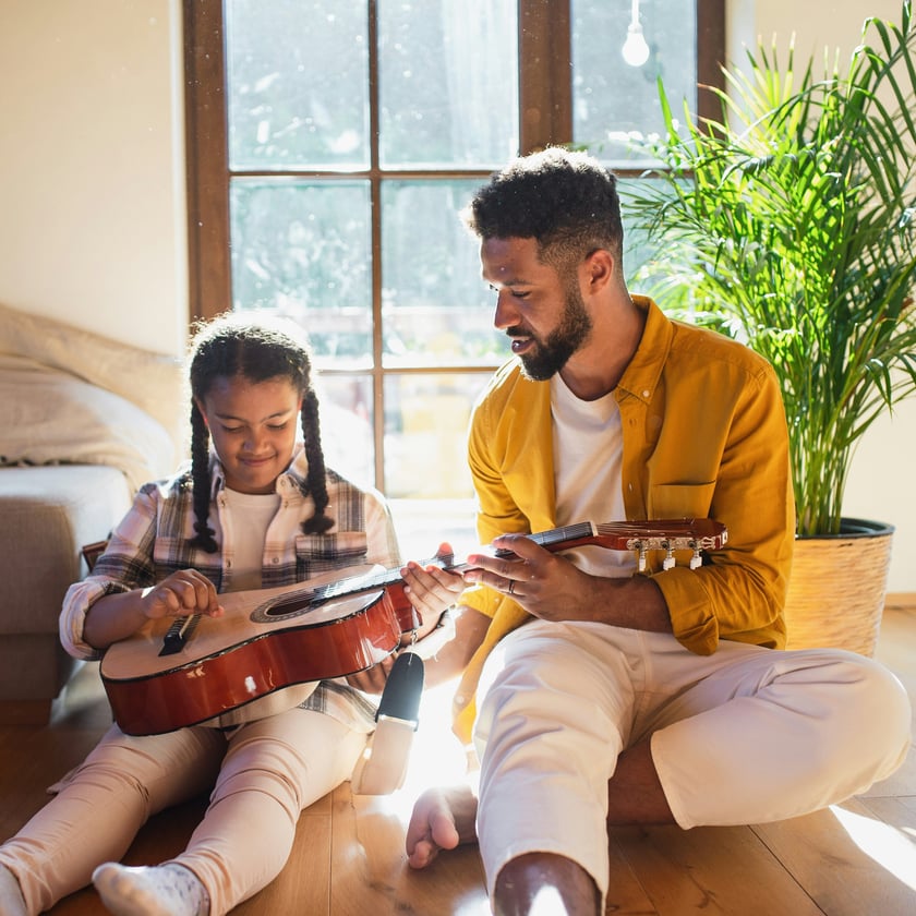 Father showing daughter guitar