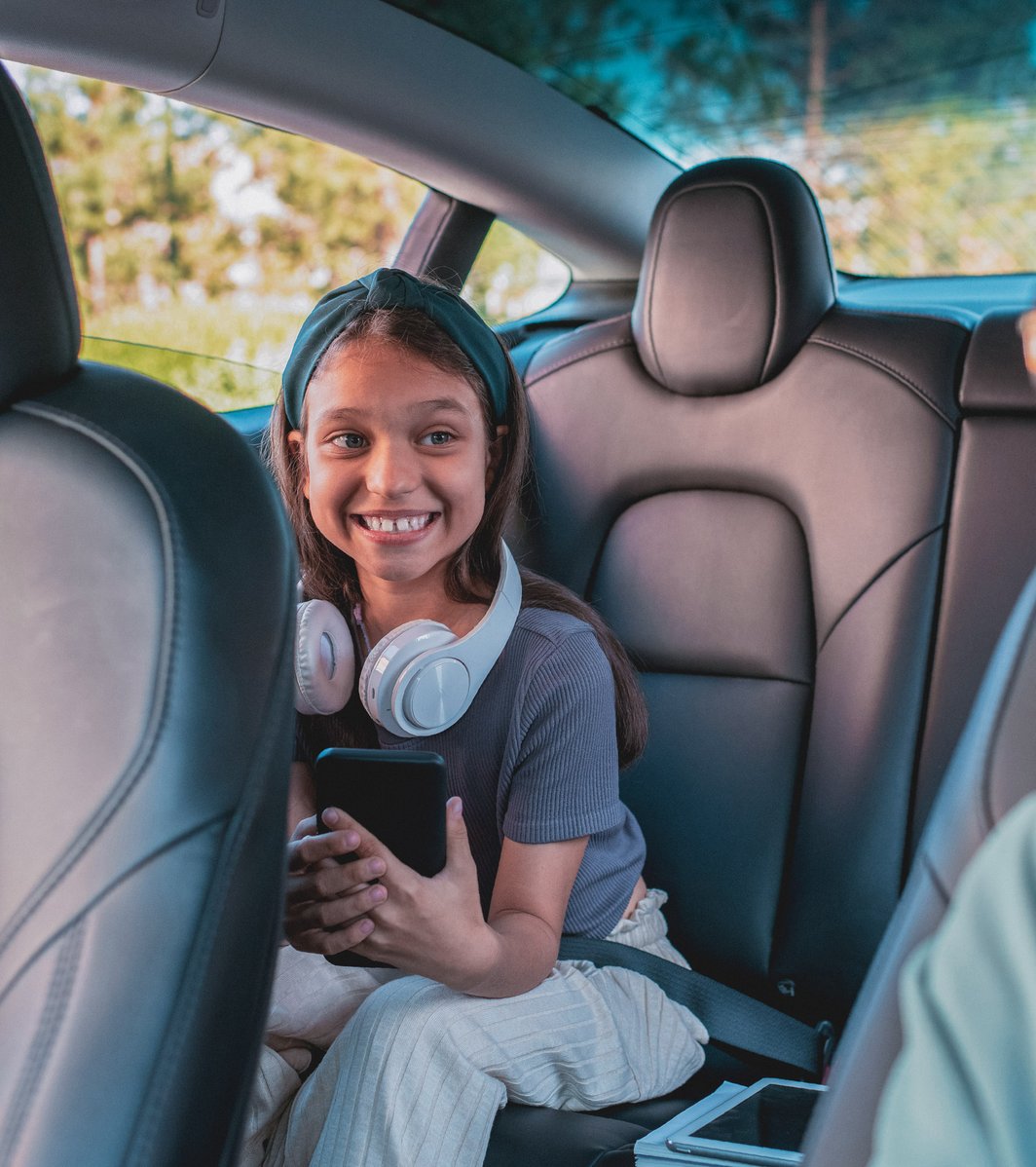 young girl smiling at her mom in the car