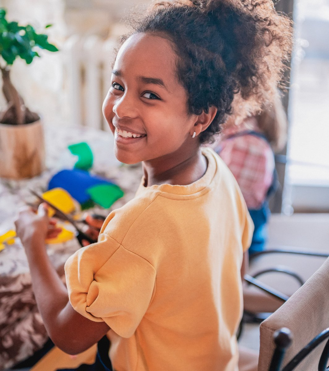 Little girl doing a craft at her kitchen table