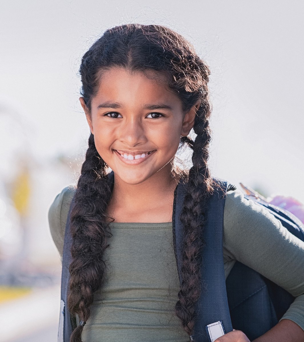 Young girl wearing a school backpack outdoors