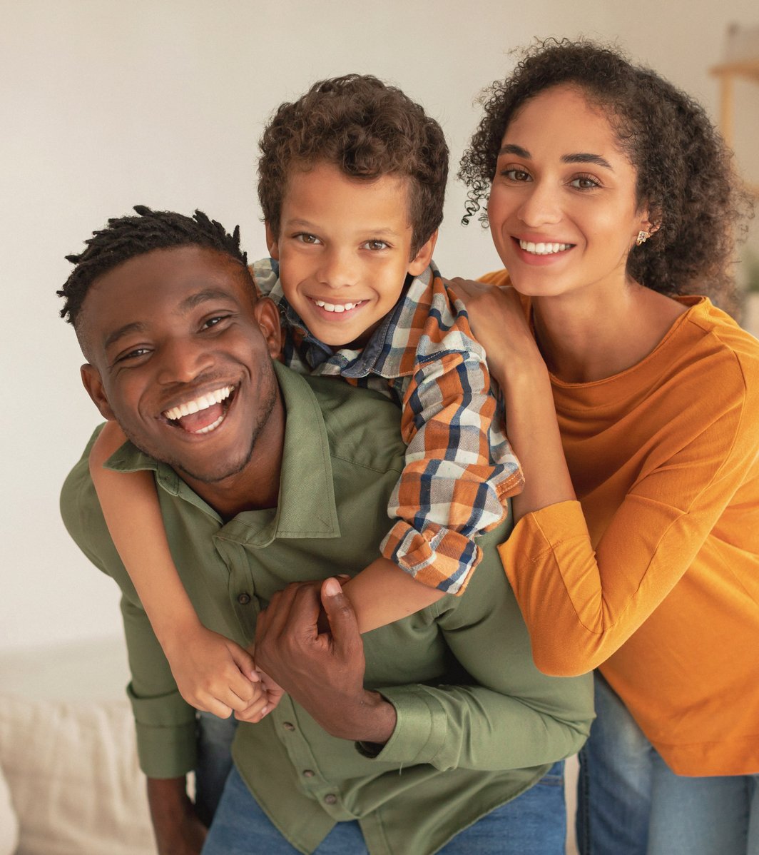 Dad and mom hugging child as a family