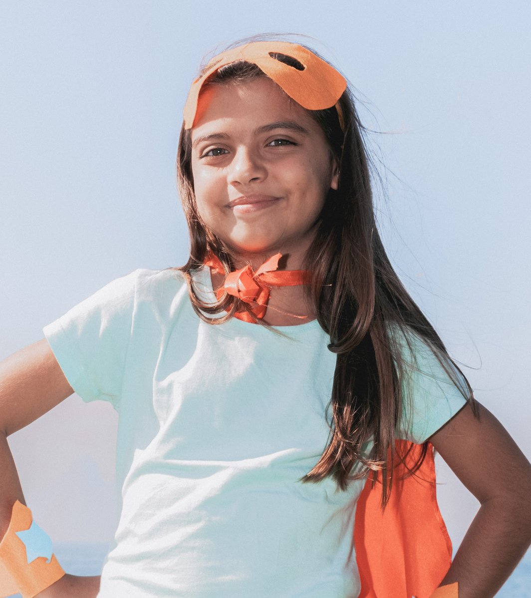 Kid smiling confidently wearing a superhero costume