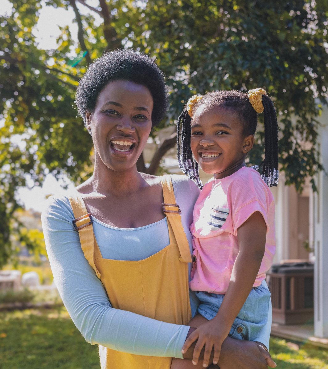 Mom holder her young daughter outside