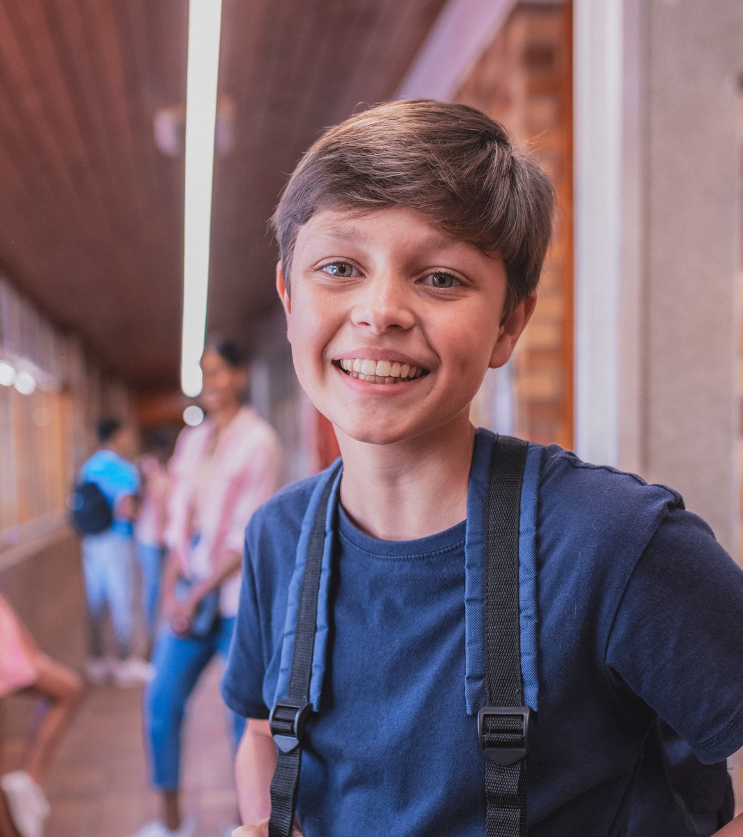 Young boy wearing a backpack at school