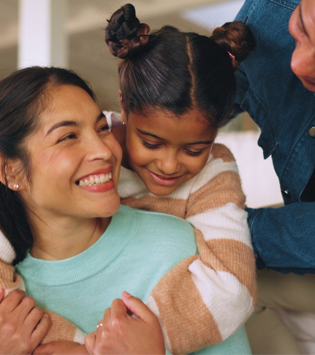 Mom Dad and daughter hugging