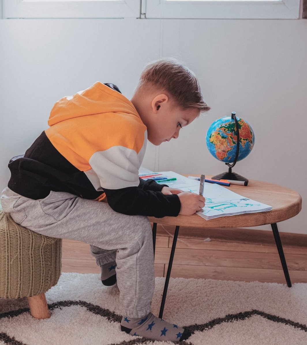 A young boy drawing at home