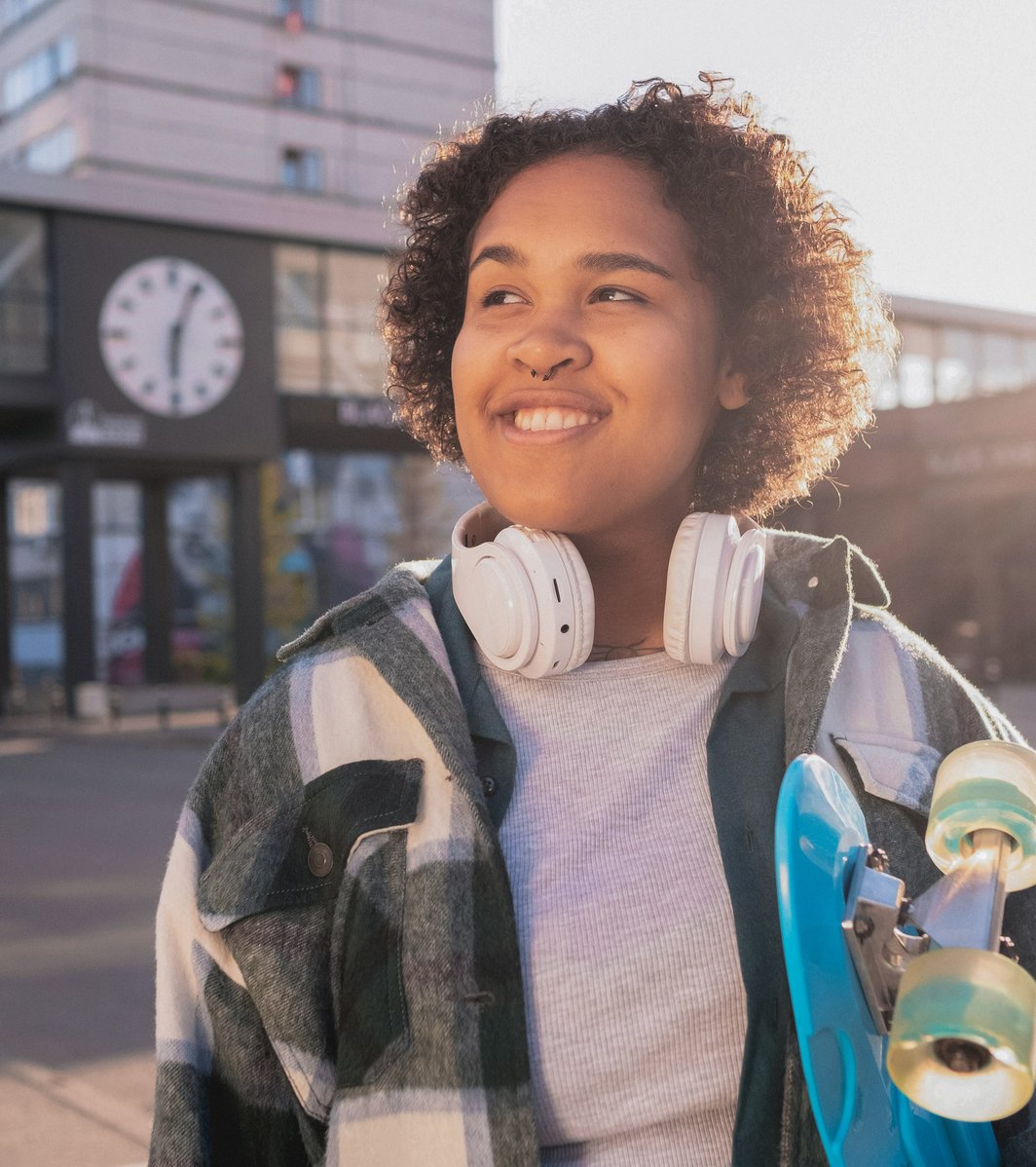 Young girl with headphones and a skateboard