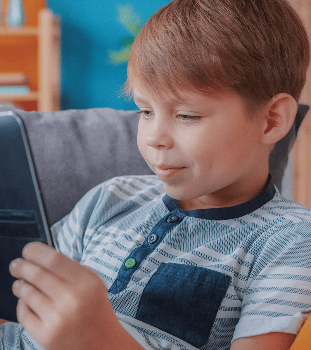 young boy smiling at computer