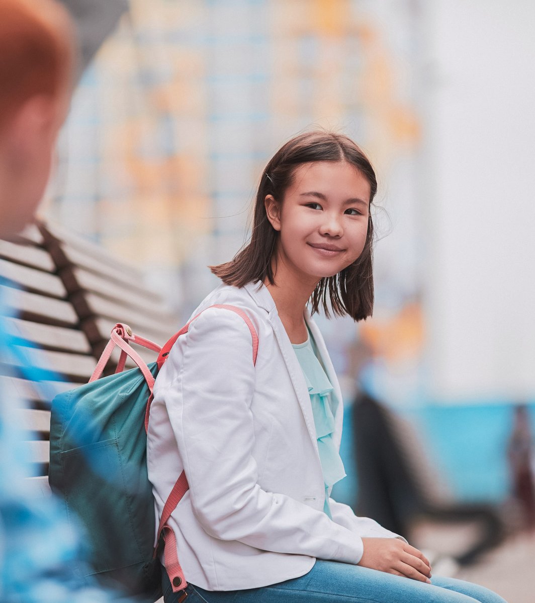 young girl smiling outside school