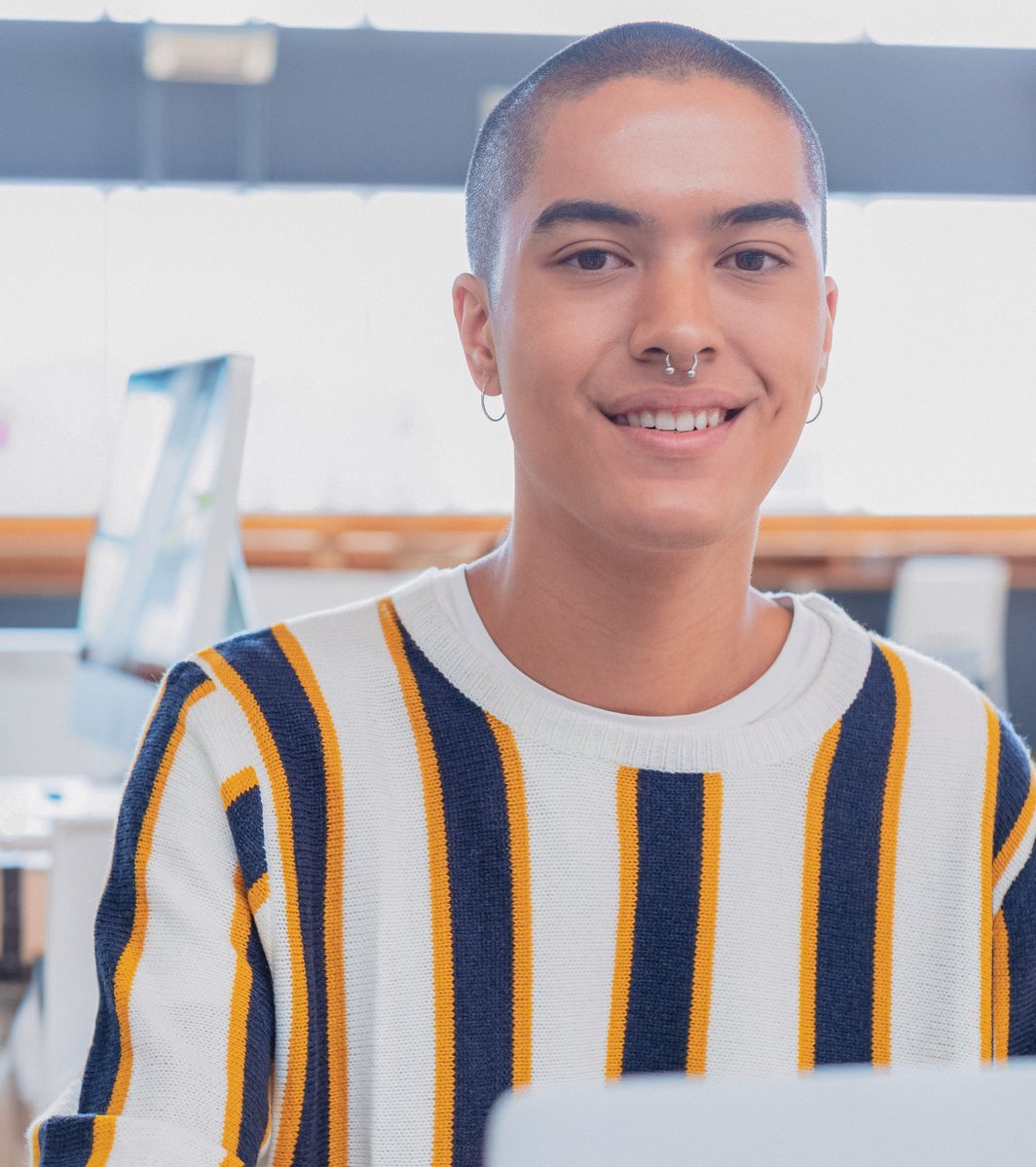 Young person at a coffee shop in a striped shirt