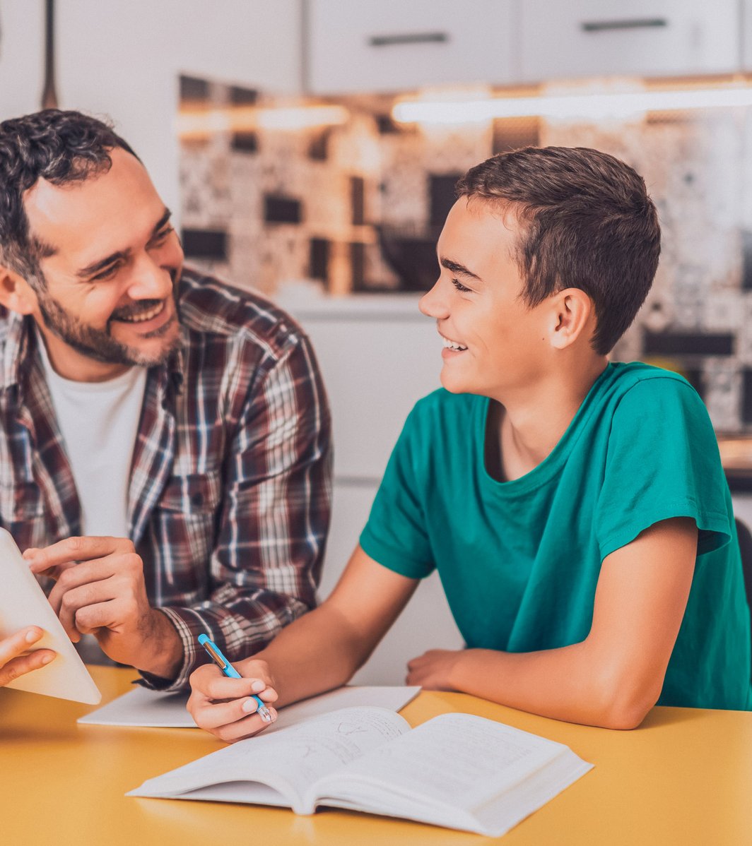 Father with his son, smiling with a tablet and book 