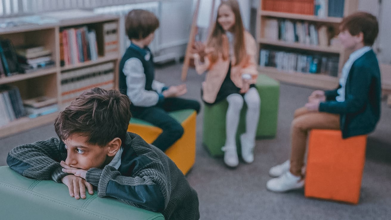 Kid sitting alone in class suffering from PTSD