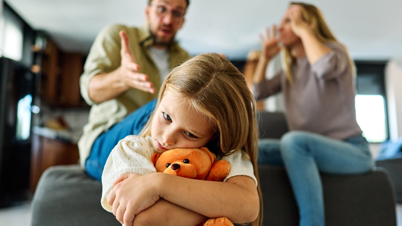 An unhappy girl experiencing unhealthy family dynamics as her parents argue