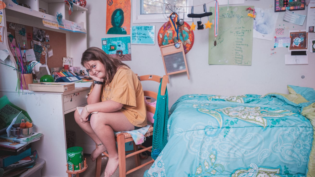 Girl sitting on a chair in her messy room