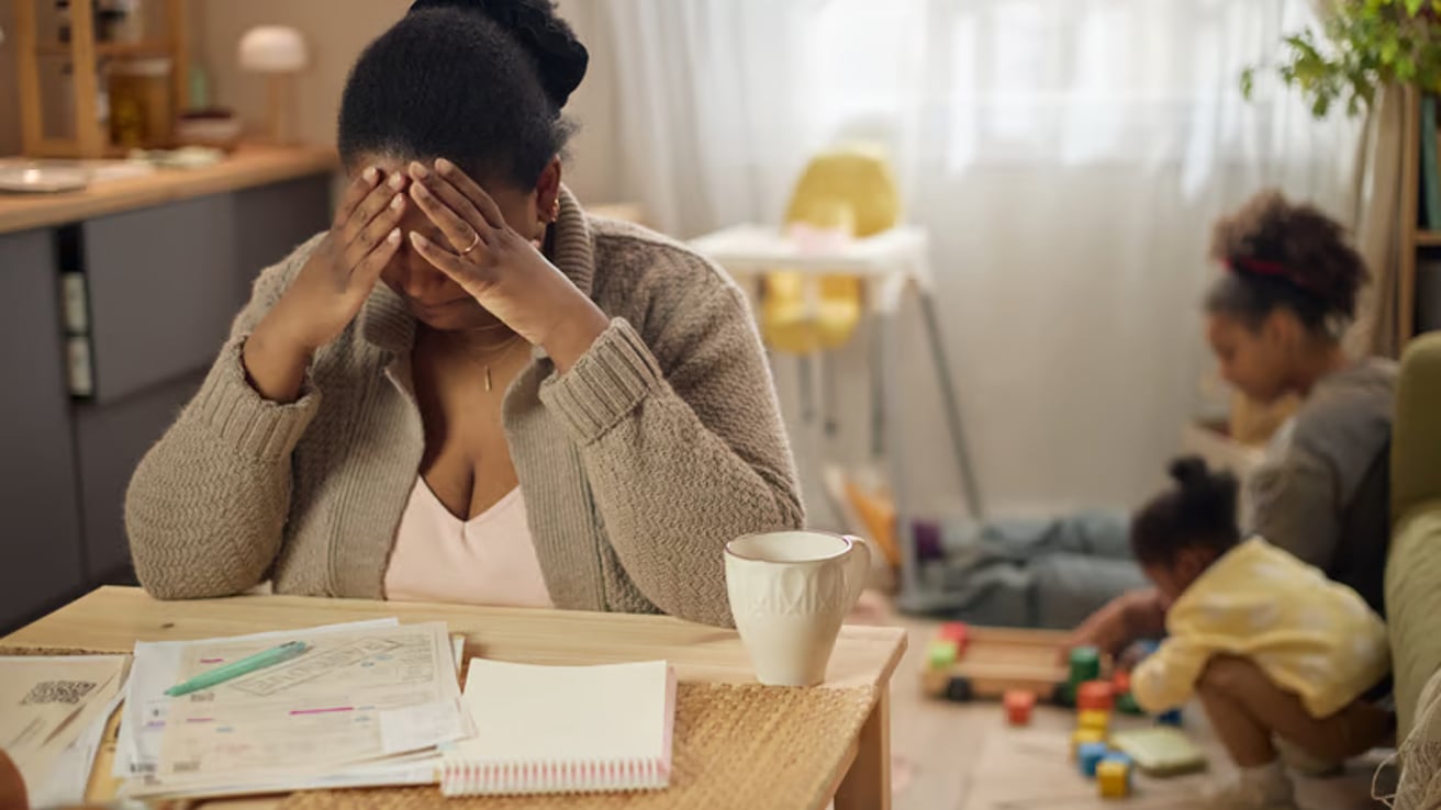 Mom feeling overwhelmed while daughters play in the background