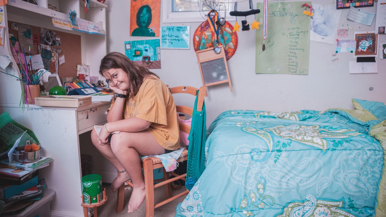 Girl sitting on a chair in her messy room