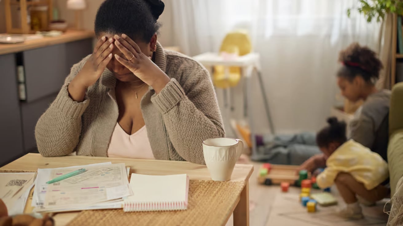 Mom feeling overwhelmed while daughters play in the background
