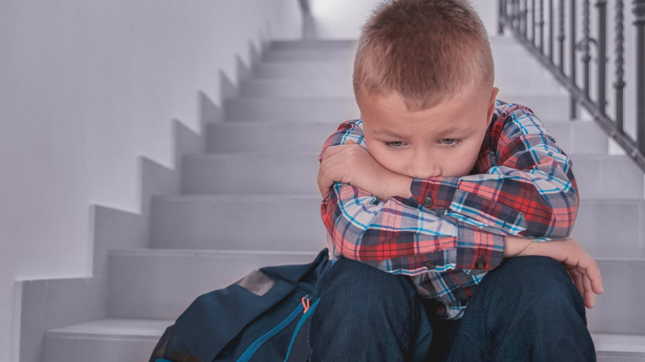 Kid sitting on the stairs sad from being bullied