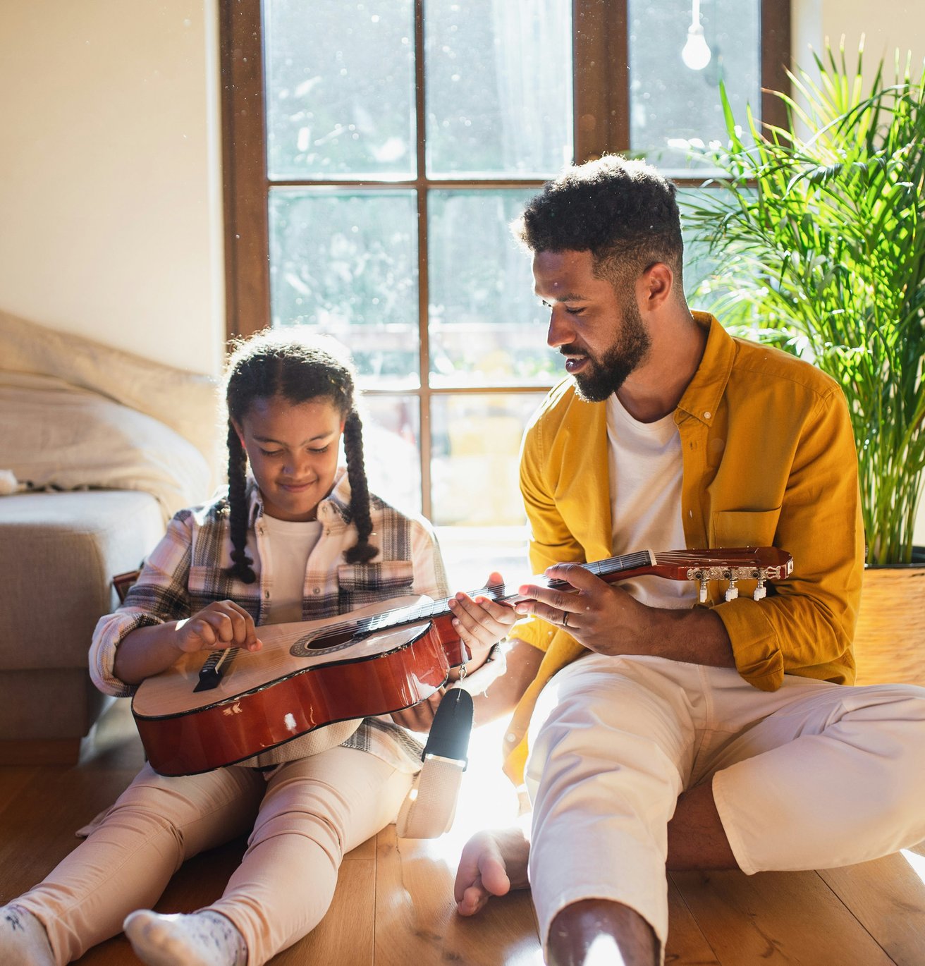 Father showing daughter guitar