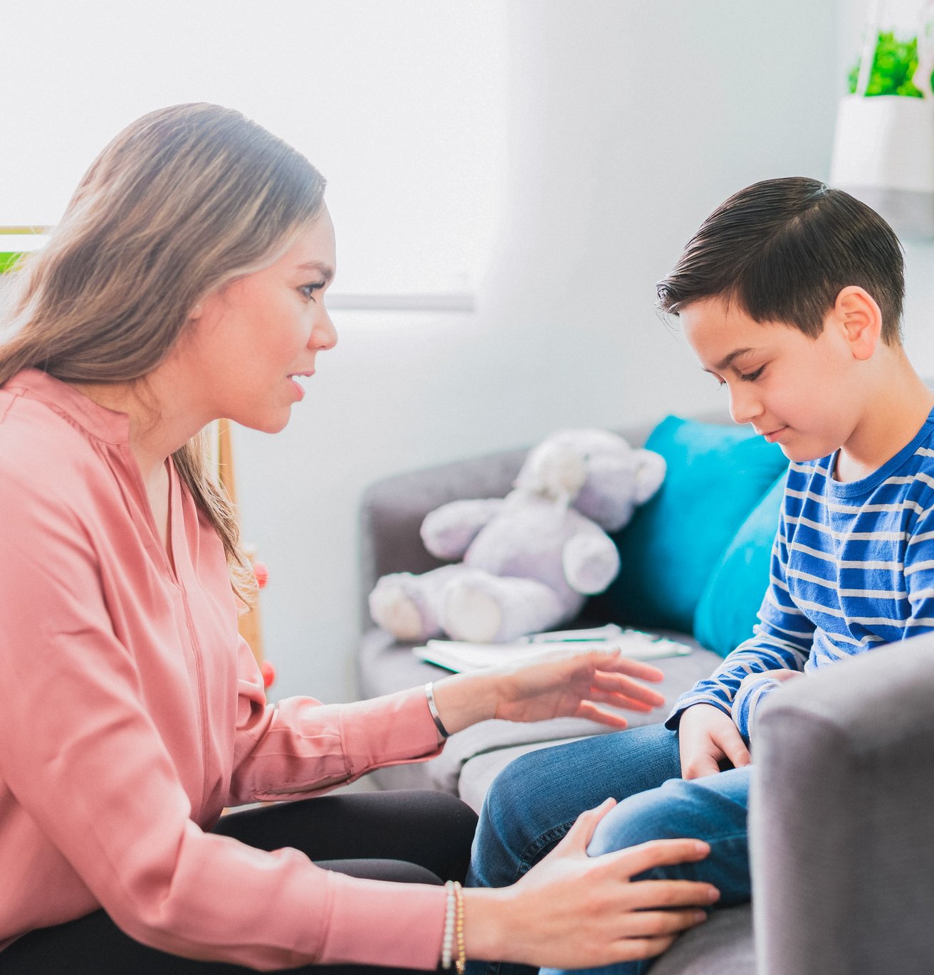 young boy is sad and getting comforted by his mother 