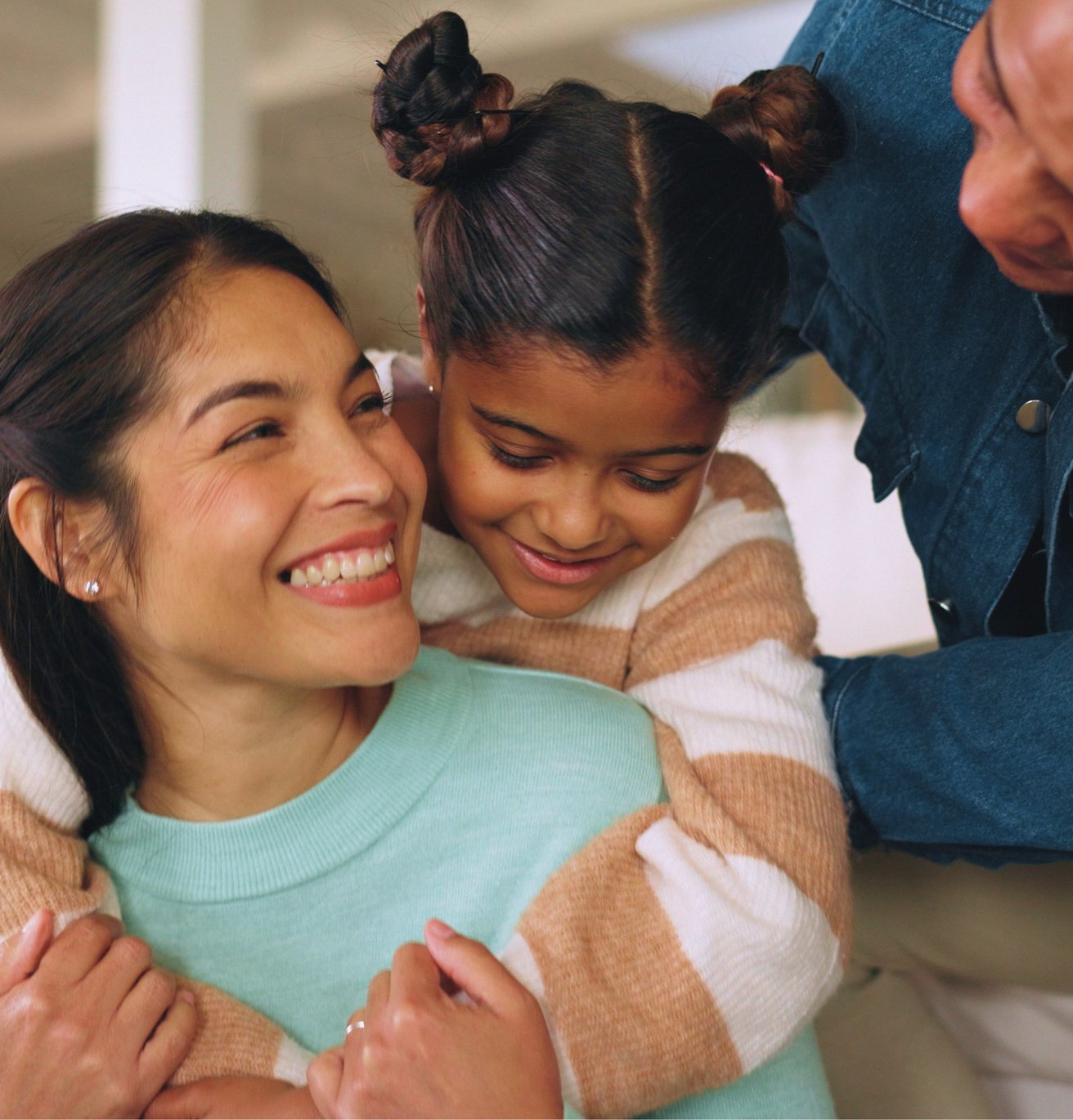 Mom Dad and daughter hugging