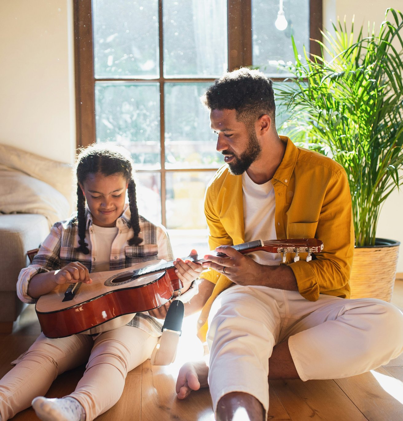 Father showing daughter guitar