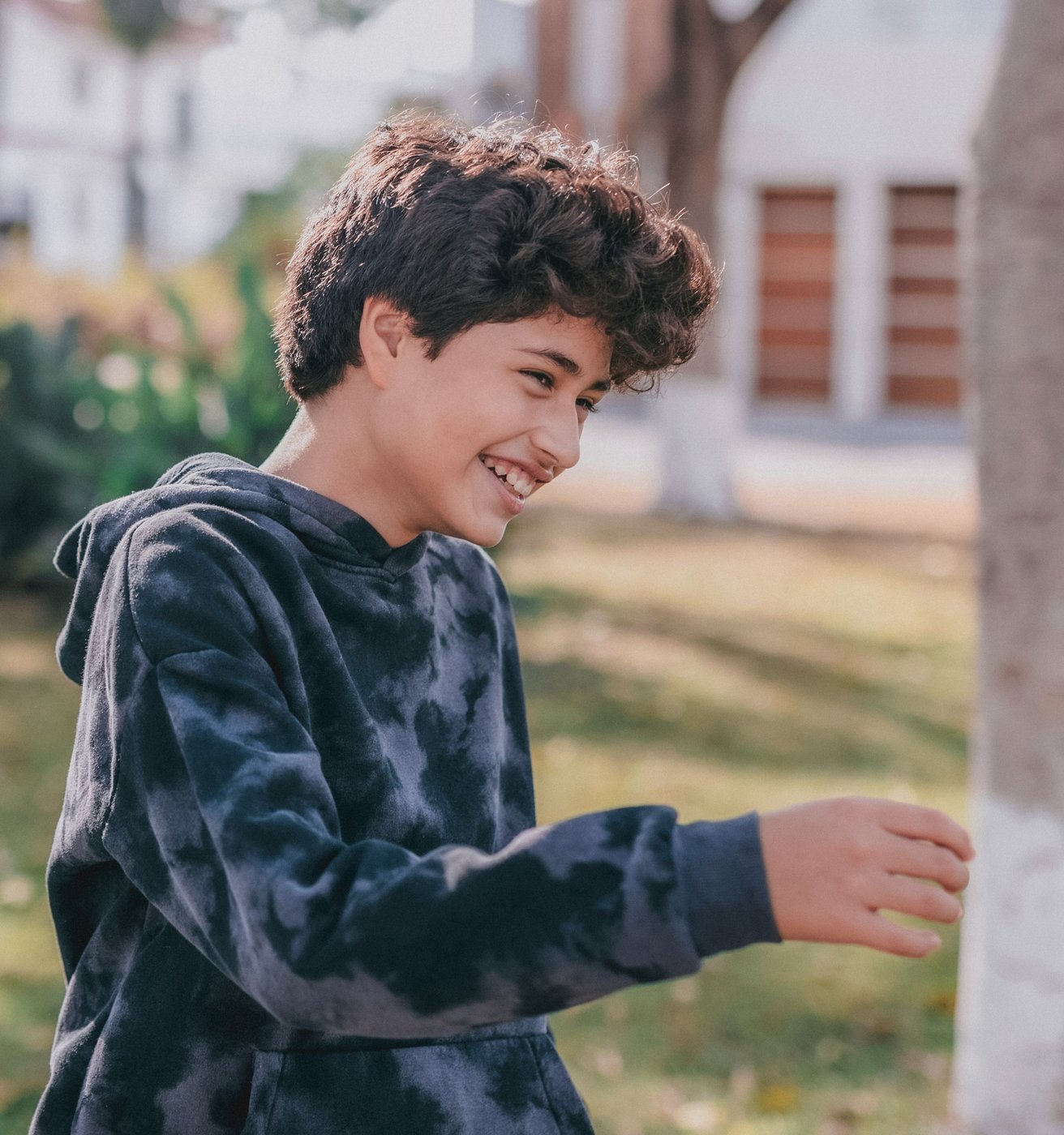 Young boy laughing outside