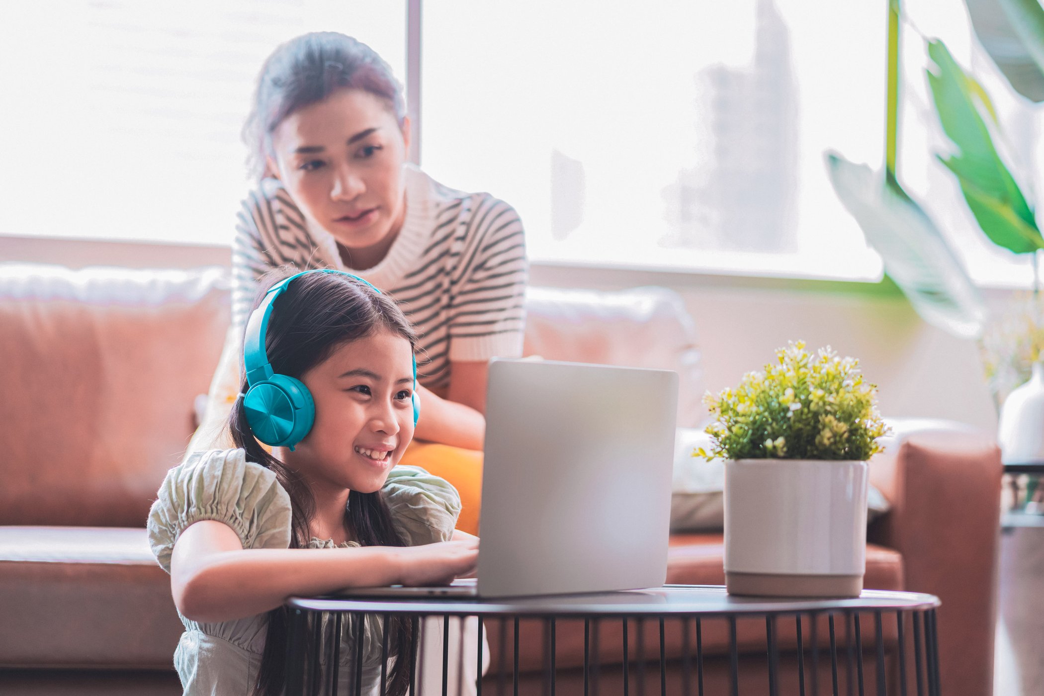 daughter smiling during therapy session in the living room and her mom is on the couch
