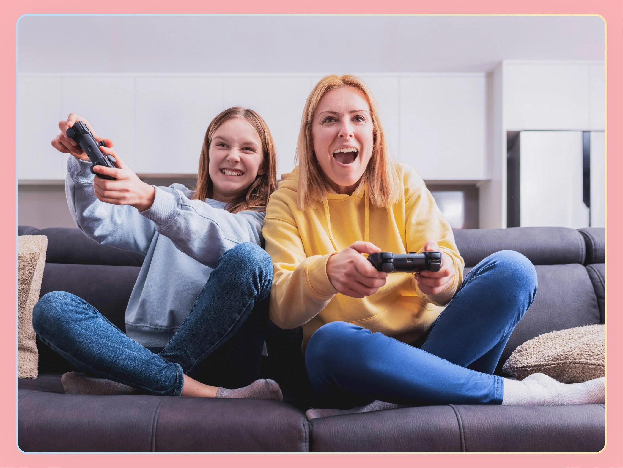 mom and daughter smiling on the couch while playing video games