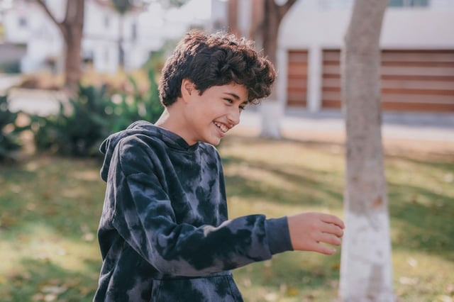 Young boy laughing outside