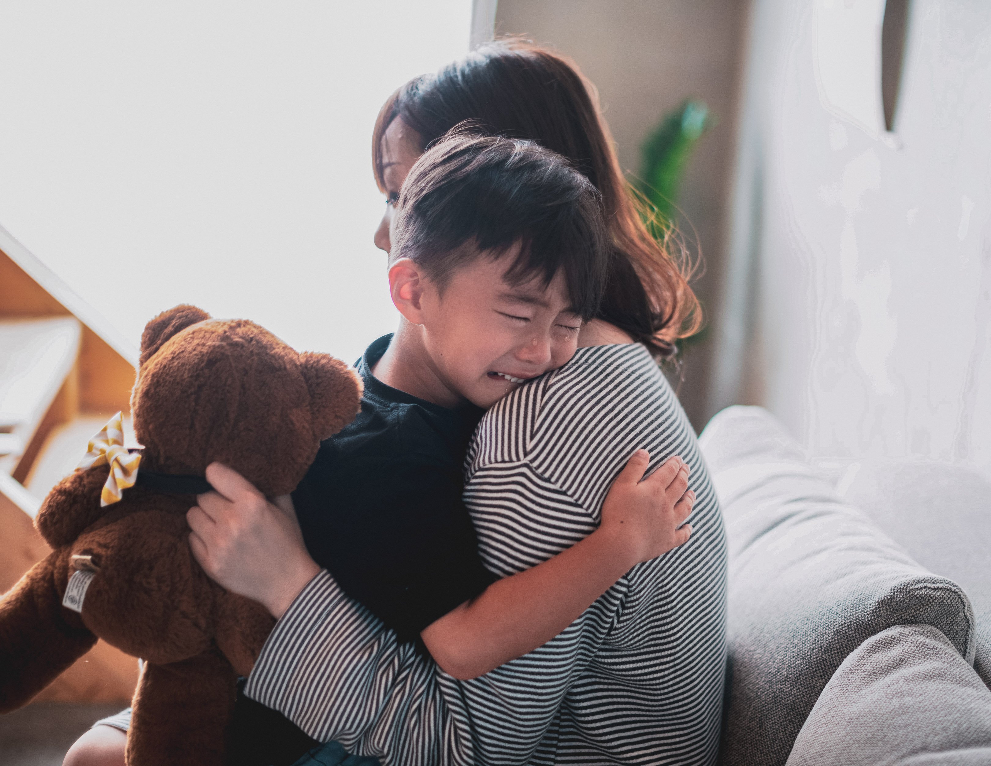 Child crying into mother's shoulder