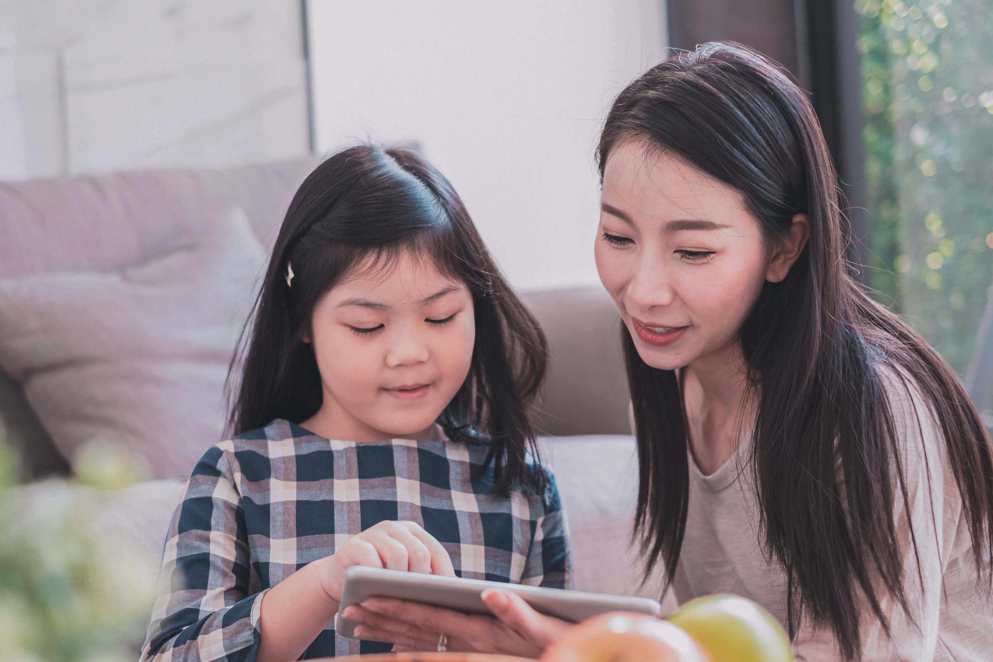 Daughter and mom playing together on an iPad