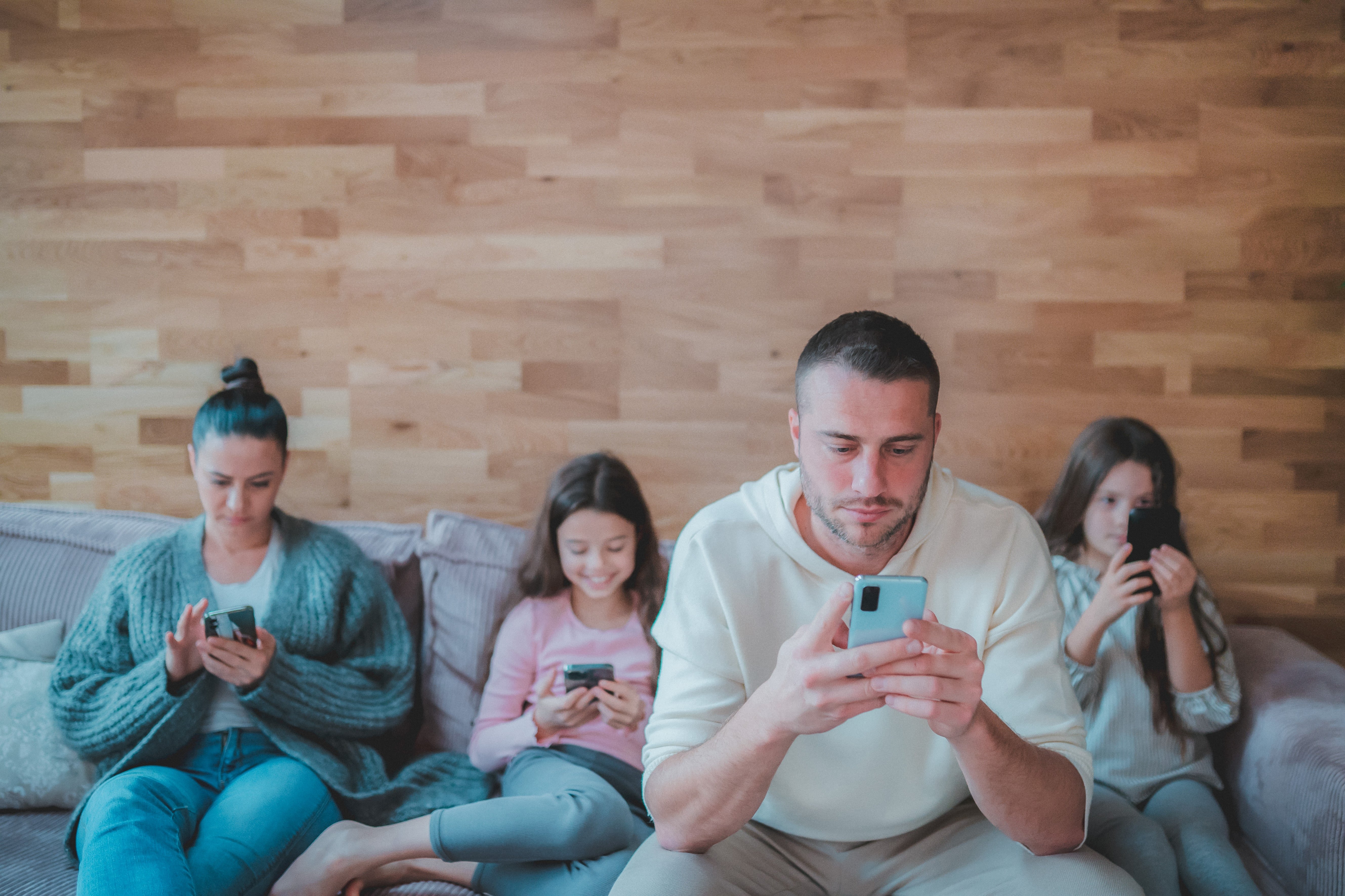 Family on their phones sitting on a couch