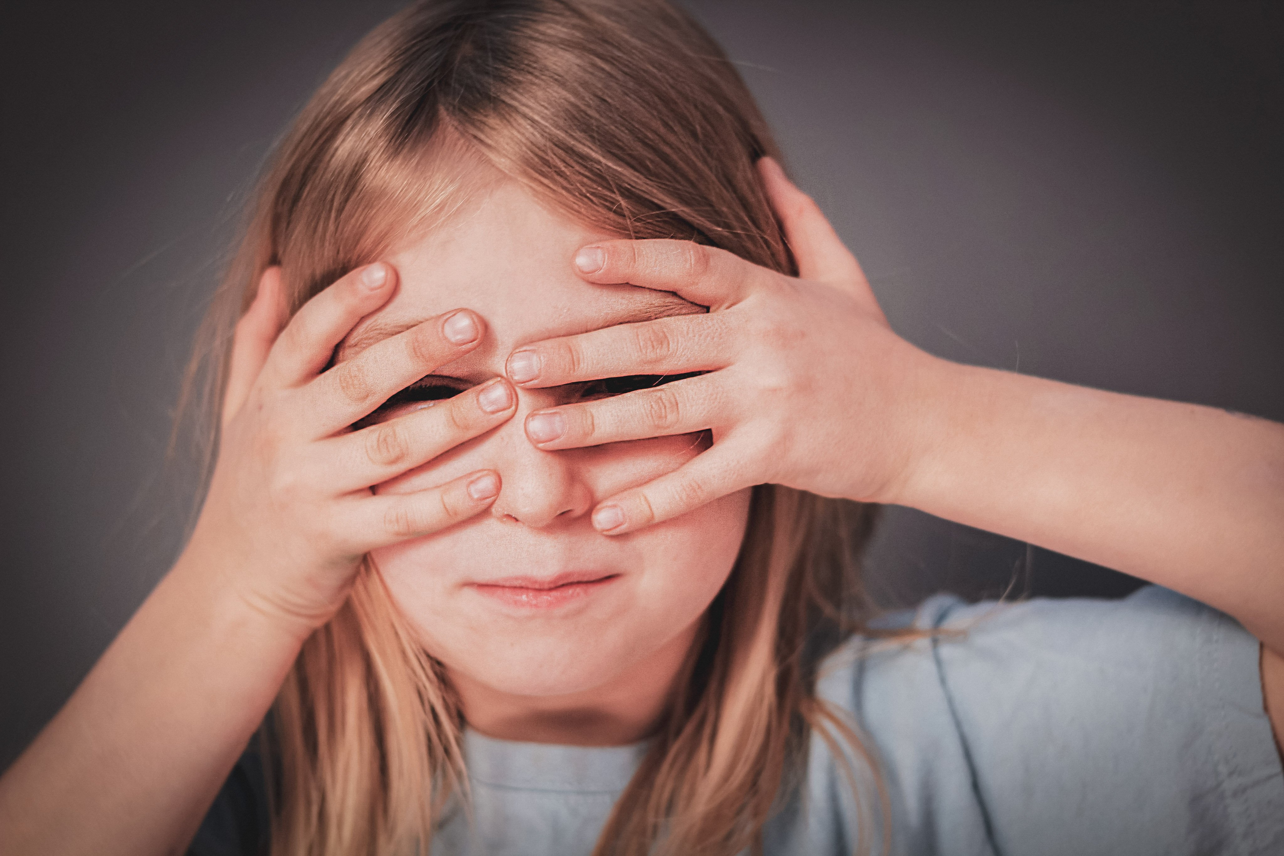 Girl covering her eyes with fingers