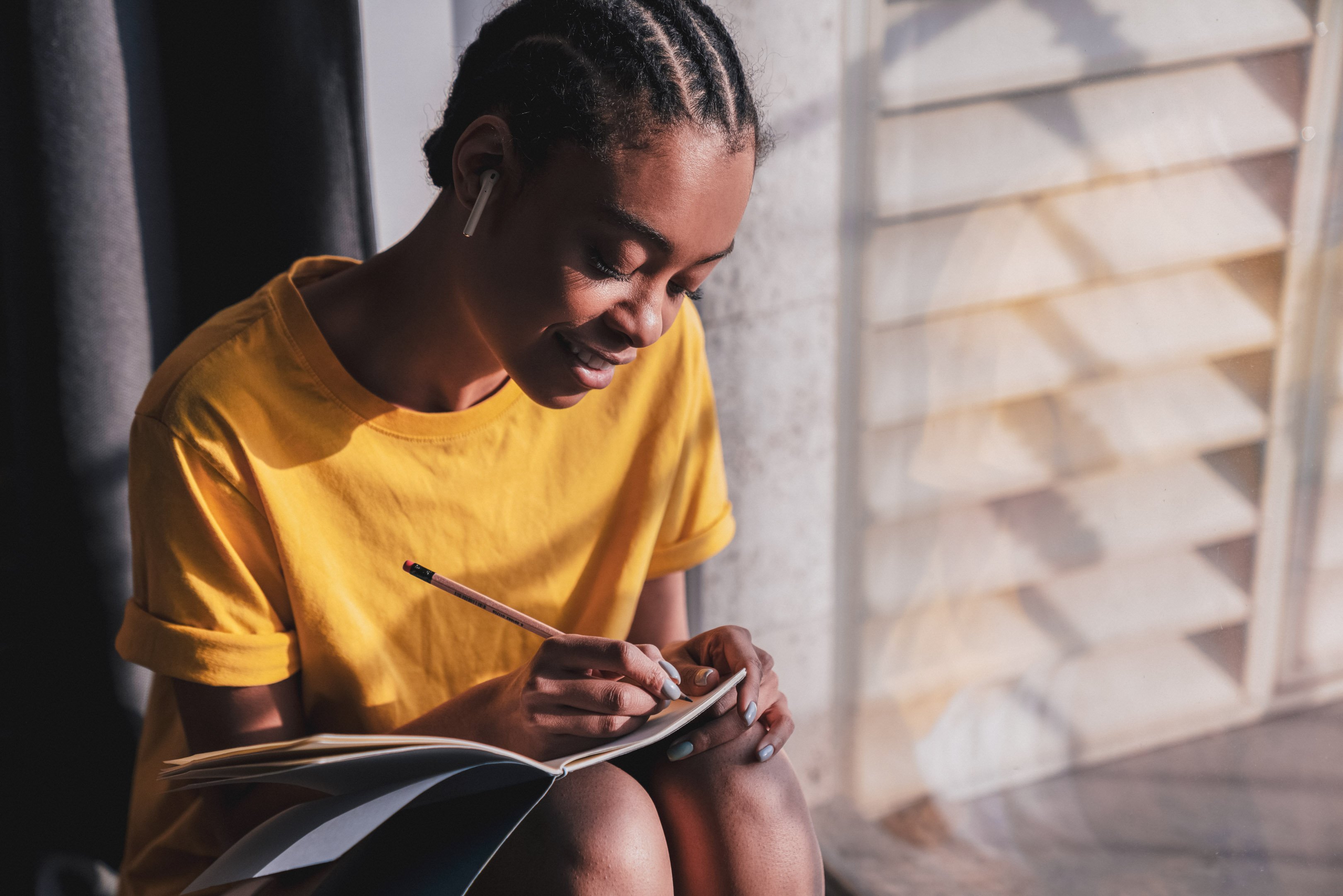 Girl listening to music and journaling