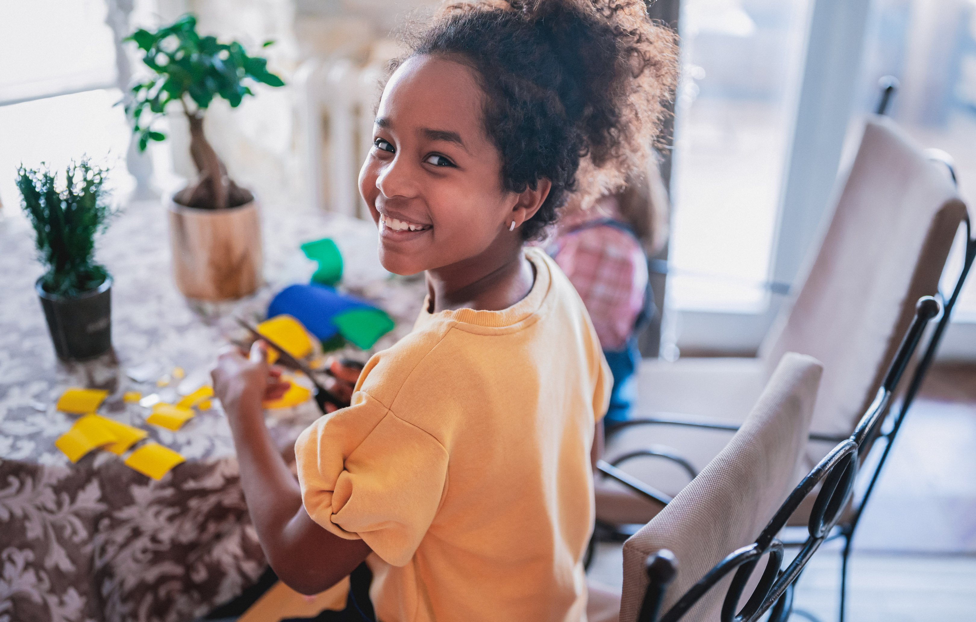 Little girl doing a craft at her kitchen table